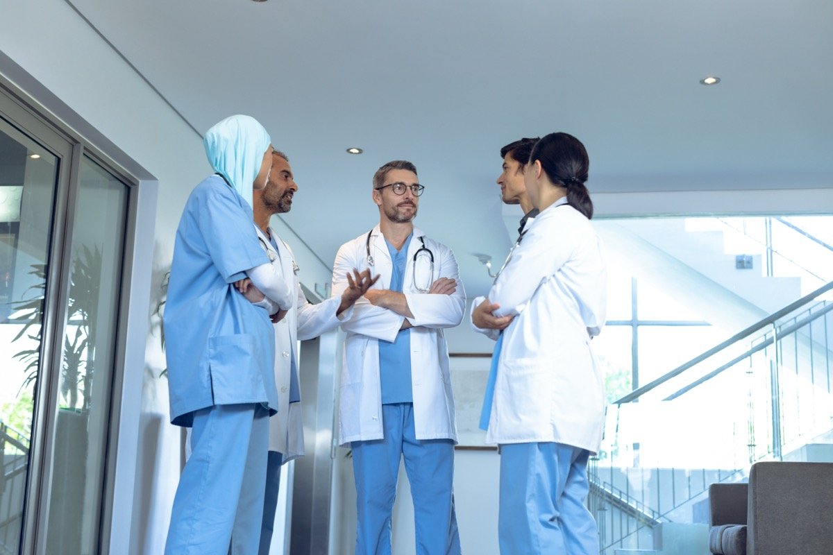 Diverse medical team discussing in a modern hospital lobby